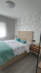 a bedroom with a large bed with blue pillows at VUT La CEPEDA in Astorga
