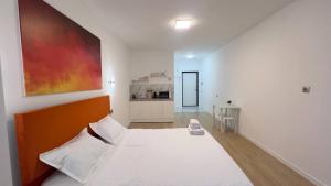 a bedroom with a large white bed and a kitchen at Aspan City Comfort 3 in Pokrovka