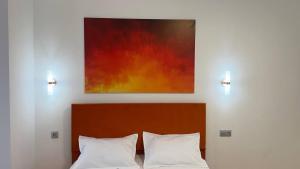 a painting above a bed with two white pillows at Aspan City Comfort 3 in Pokrovka
