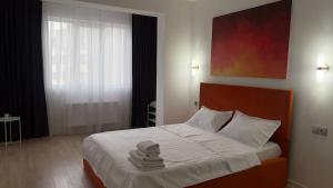 a bedroom with a bed with towels on it at Aspan City Comfort 3 in Pokrovka
