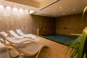 a group of chairs and a pool in a room at De Stefano Palace Luxury Hotel in Ragusa