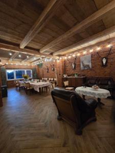 a restaurant with tables and couches in a room at Leśna Ostoja in Goworów