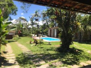 a yard with a swimming pool and a tree at Casa Compartilhada na CBF, granja comary in Teresópolis +8 photos