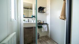 a small bathroom with a sink and a mirror at ZEcamping 4 étoiles familial avec piscine couverte in Laroque-des-Albères