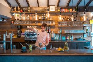 a man standing behind a bar with his arm up at ZEcamping 4 étoiles familial avec piscine couverte in Laroque-des-Albères +33 photos