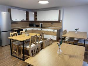 a kitchen with wooden tables and white cabinets at Penzion Vejprty in Vejprty