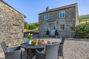 a table and chairs in front of a stone house at 2 Bed in Middleton oc-m29515 in Middleton