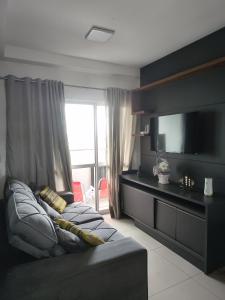 a living room with a couch and a flat screen tv at Casa Rebello - Pousada in Itajaí