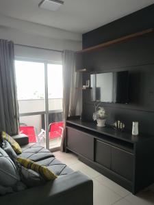 a living room with a couch and a flat screen tv at Casa Rebello - Pousada in Itajaí
