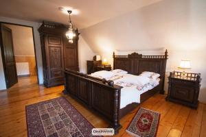 a bedroom with a large wooden bed with white sheets at Casa Poveste Pensiunea-Muzeu in Câmpulung Moldovenesc +63 photos