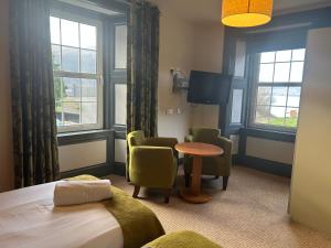 a hotel room with a bed and chairs and a table at Rowardennan Hotel in Rowardennan