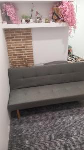 a gray bench in a room with pink flowers at House Marios airport 3 in Spata