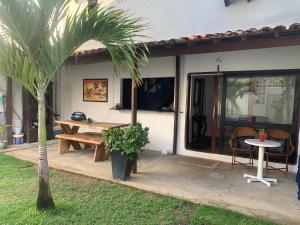 a patio with a table and a bench next to a house at casa aconchegante proximo a praia in Maceió