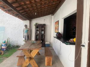 a table and bench in a patio with a statue at casa aconchegante proximo a praia in Maceió