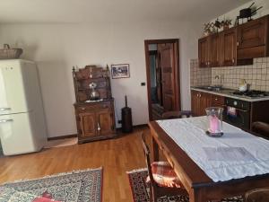 a kitchen with a table and a white refrigerator at Ginetta in Madonna del Sasso +18 photos