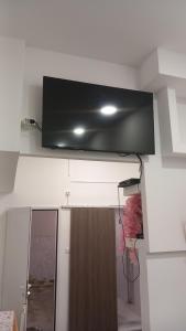 a flat screen tv hanging from the ceiling of a room at House Marios airport 3 in Spata