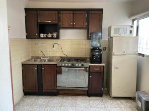 a kitchen with a stove and a refrigerator at Se Renta Casa in Saltillo