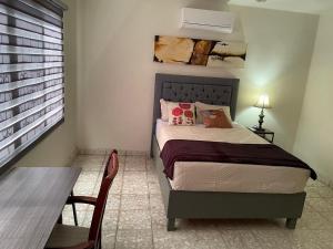 a bedroom with a bed and a table and a dining room at Se Renta Casa in Saltillo