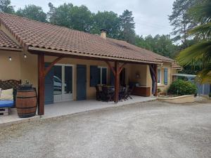 a house with a pavilion with a table and chairs at La Marceline Gîte avec piscine près de Lascaux IV in Aubas
