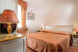 a bedroom with a bed and a lamp and a chair at Ambassador Tre Rose in Venice