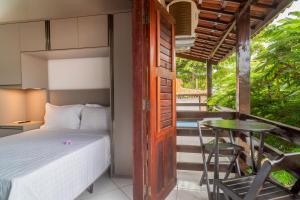 a bedroom with a bed and a table on a balcony at Flat dboa in Jericoacoara