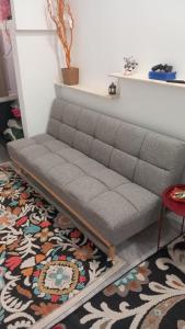 a couch in a living room with a rug at House Marios airport 3 in Spata
