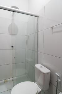 a white bathroom with a toilet and a shower at Flat dboa in Jericoacoara +39 photos