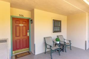 a porch with two chairs and a red door at Gatehouse Condo by Beyond Expectations w Views in Gatlinburg