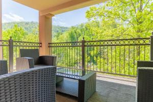 a screened porch with chairs and a glass table and a fence at Gatehouse Condo by Beyond Expectations w Views in Gatlinburg