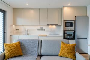 a kitchen with a couch with two yellow pillows at Victory Suites in Gibraltar
