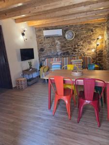 a dining room with a table and colorful chairs at Casa do Tear in Sobreira Formosa