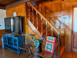 a living room with a staircase and a television at Cozy Highland Cattle-View Suite Peaceful, Private Pet-Friendly in Loudon