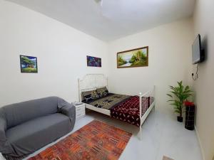 a living room with a bed and a couch at Friendlyhomes in Al Ain