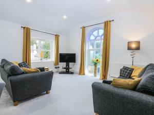 a living room with two couches and a tv at Capel Y Ffynnon in Llandudno Junction