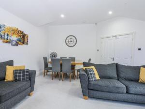 a living room with two couches and a table at Capel Y Ffynnon in Llandudno Junction