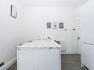 a white kitchen with a white island in a room at Capel Y Ffynnon in Llandudno Junction +21 photos