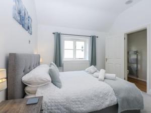 a bedroom with a bed and a table and a window at Capel Y Ffynnon in Llandudno Junction