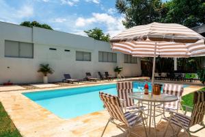 a table with an umbrella and chairs next to a pool at Gardin Home in Cali