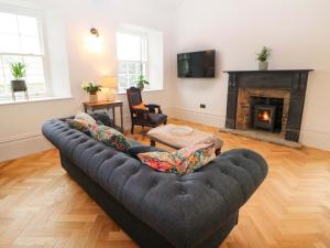 a living room with a couch and a fireplace at The Reading Room in Grindleford Bridge