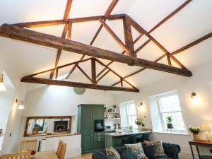 a living room with wooden beams and a room with a couch at The Reading Room in Grindleford Bridge
