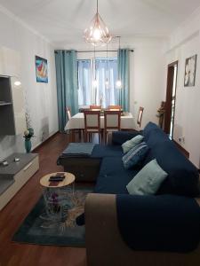 a living room with a blue couch and a dining room at Madeira Home Holidays in Caniço +18 photos
