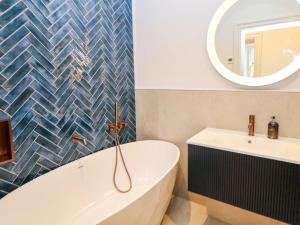a bathroom with a tub and a sink and a mirror at The Reading Room in Grindleford Bridge +23 photos