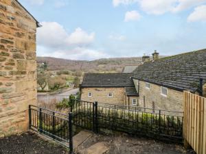a view of an old stone building with a fence at The Reading Room in Grindleford Bridge