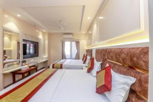 a hotel room with two beds and a television at Avtar new delhi railway station in New Delhi +43 photos