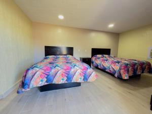 a bedroom with two beds in a room at Vanguard Motel in Ormond Beach +3 photos