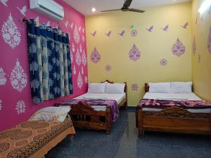 a room with two beds and birds on the wall at Vibheeshan Villa in Yelagiri