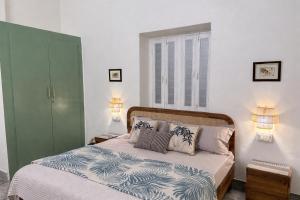 a bedroom with a bed with pillows and a window at Ardor Homestay in Jabalpur +28 photos
