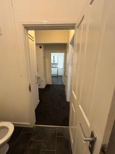 a hallway of a bathroom with a toilet and a door at One Bedroom flat in Doncaster Prime Location in Doncaster