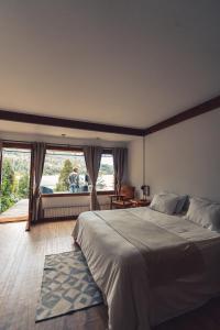 a bedroom with a large bed and a large window at El Remanso del Lago in Villa La Angostura