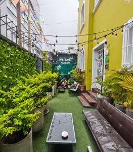 a courtyard of a building with plants and a table at The Secret Garden Hostel in Lima